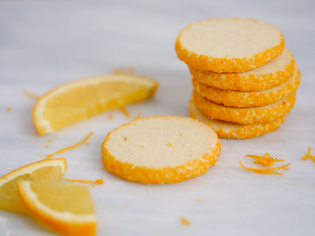 Stack of VanEllin Orange Key cookies with orange slices on a white background